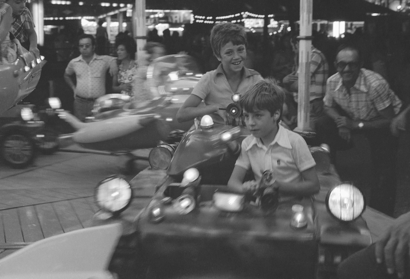 Dos niños montados en una de las atracciones de la Feria