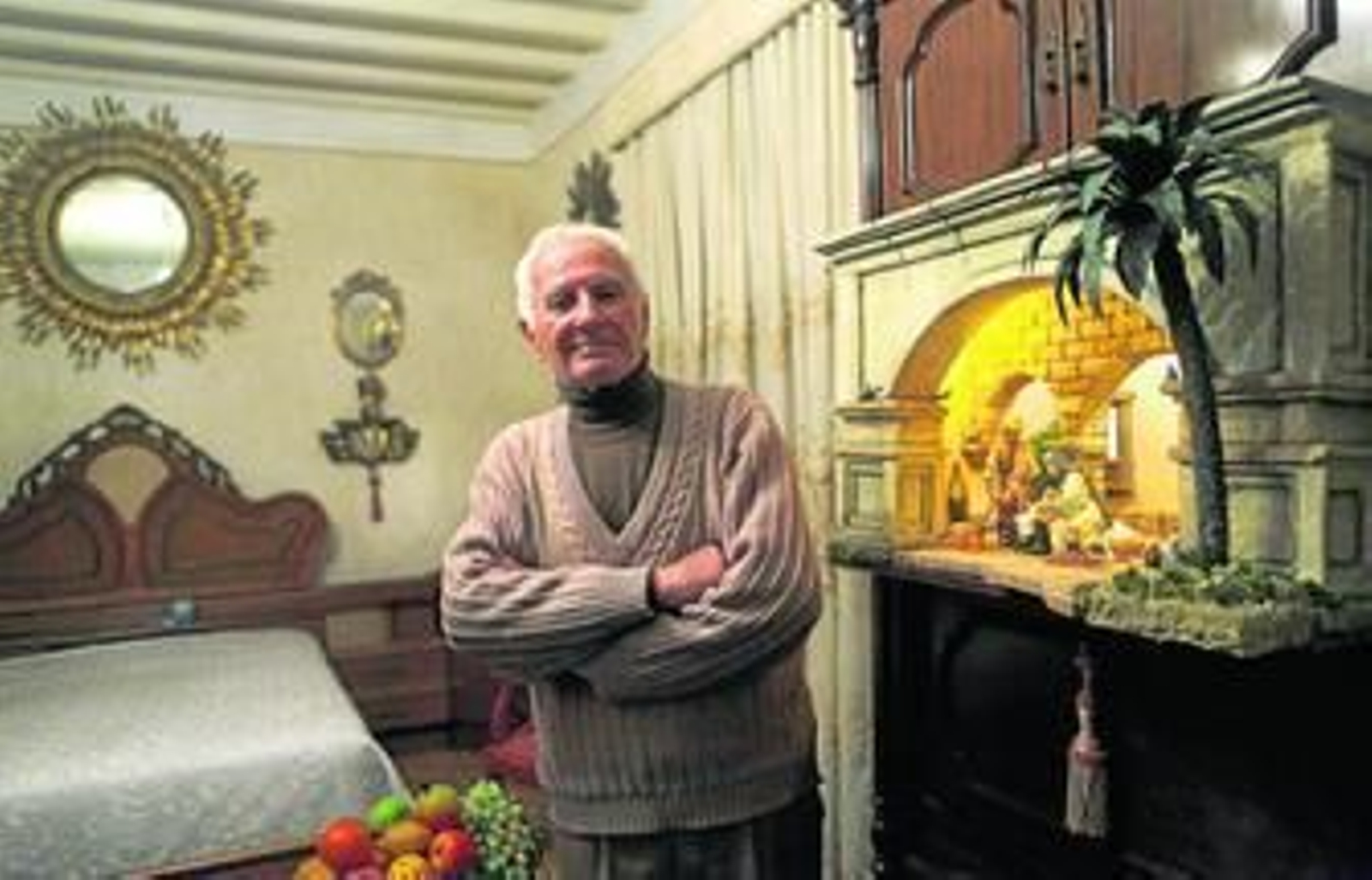 Joaquín Noya posa delante de su cama ante el Belén que ha instalado este año en su dormitorio, abierto al público hasta el 5 de enero.