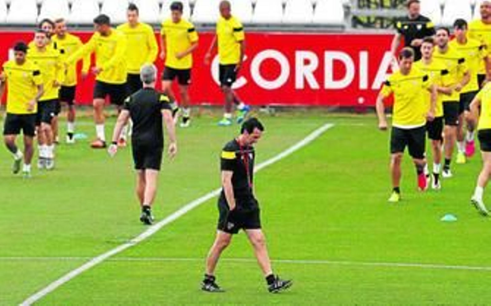 Emery, pensativo con el preparador físico, Sergio Domínguez, al frente del grupo al fondo.