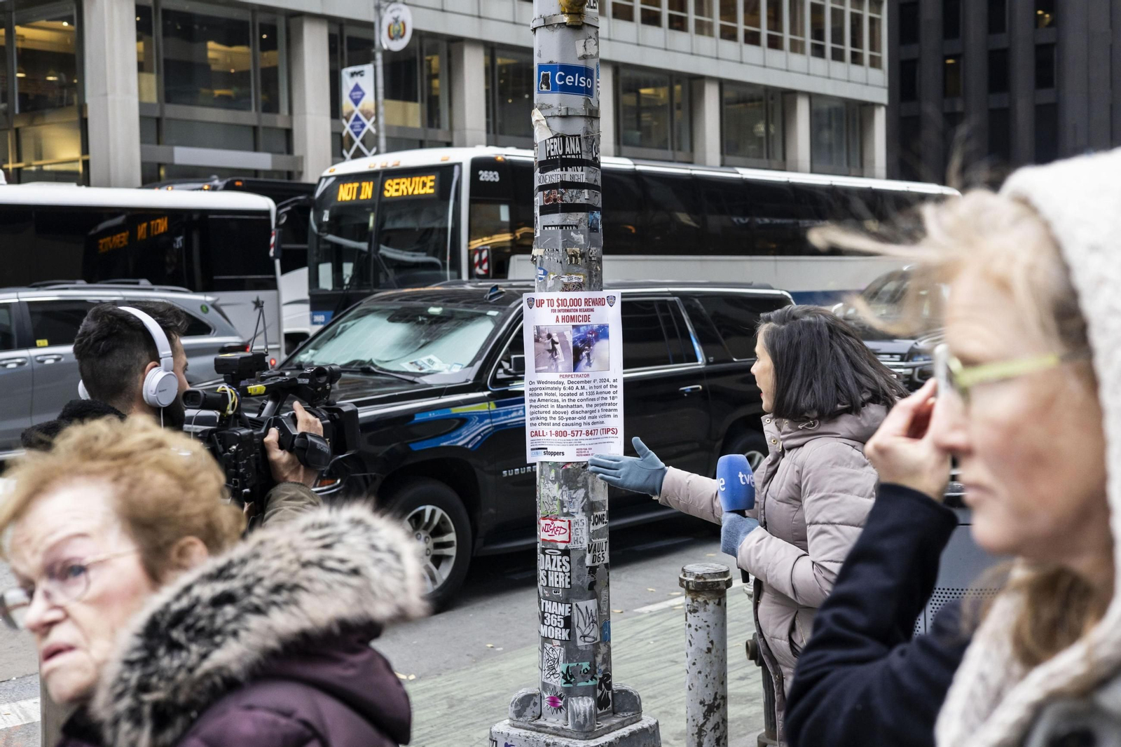 Una peridista realiza una información sobre el crimen junto a uno de los carteles colocados por la Policía de Nueva York.