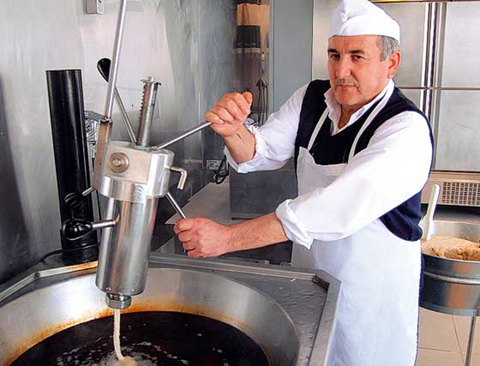 Churrería Freiduría La Plaza
Propietario: Juan Manuel Ballesteros López · Su hijo, Juan Manuel Ballesteros lo acompaña en las 
faenas
Puestos V-6, V-7
Género:Especialidad en churros y patatas fritas
Juan Manuel Ballesteros comenzó su andadura en este puesto con la apertura del nuevo Mercado de Abastos, pero le avala la garantía de cincuenta años en el gremio. Un negocio familiar, que va de padres a hijos, y que tiene dos puntos de venta en Chiclana. 
Su principal clientela son los comercios de la zona, y el género de sus productos de la propia plaza. Entre sus especialidades destacan los churros y las patatas fritas, pero también ofrecen pollo y pescaíto frito los fines de semana.



Foto: Paco Periñán