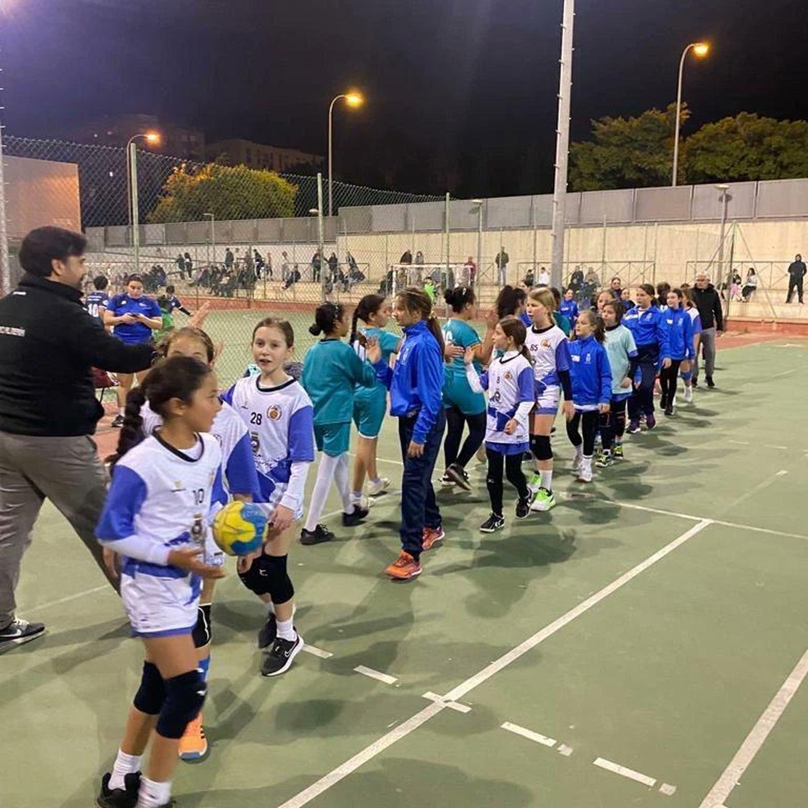 Saludo entre equipos durante una jornada de los Juegos Deportivos Municipales.