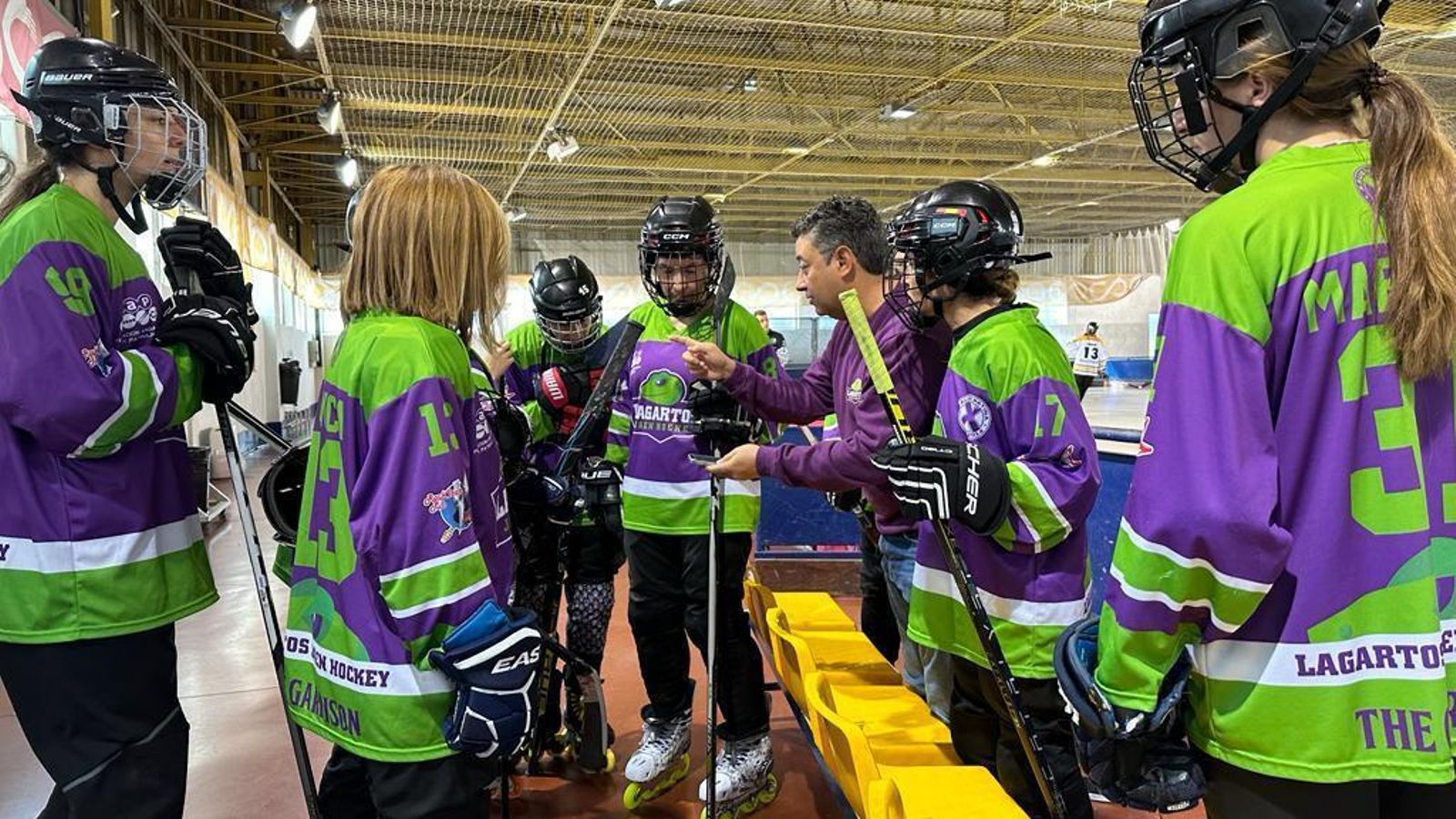 Las chicas de Lizards Hockey Linea recibiendo instrucciones de su entrenador