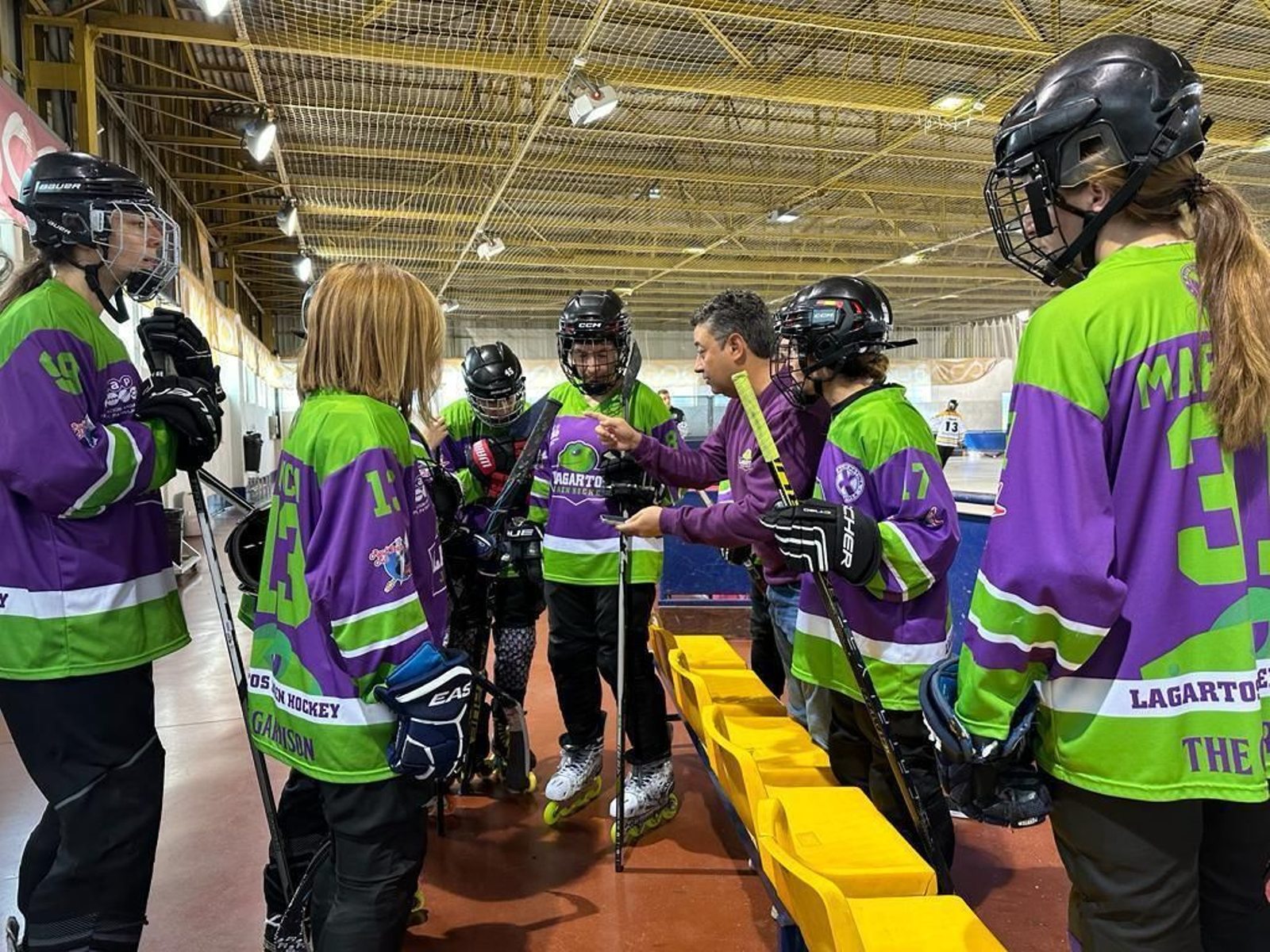 Las chicas de Lizards Hockey Linea recibiendo instrucciones de su entrenador
