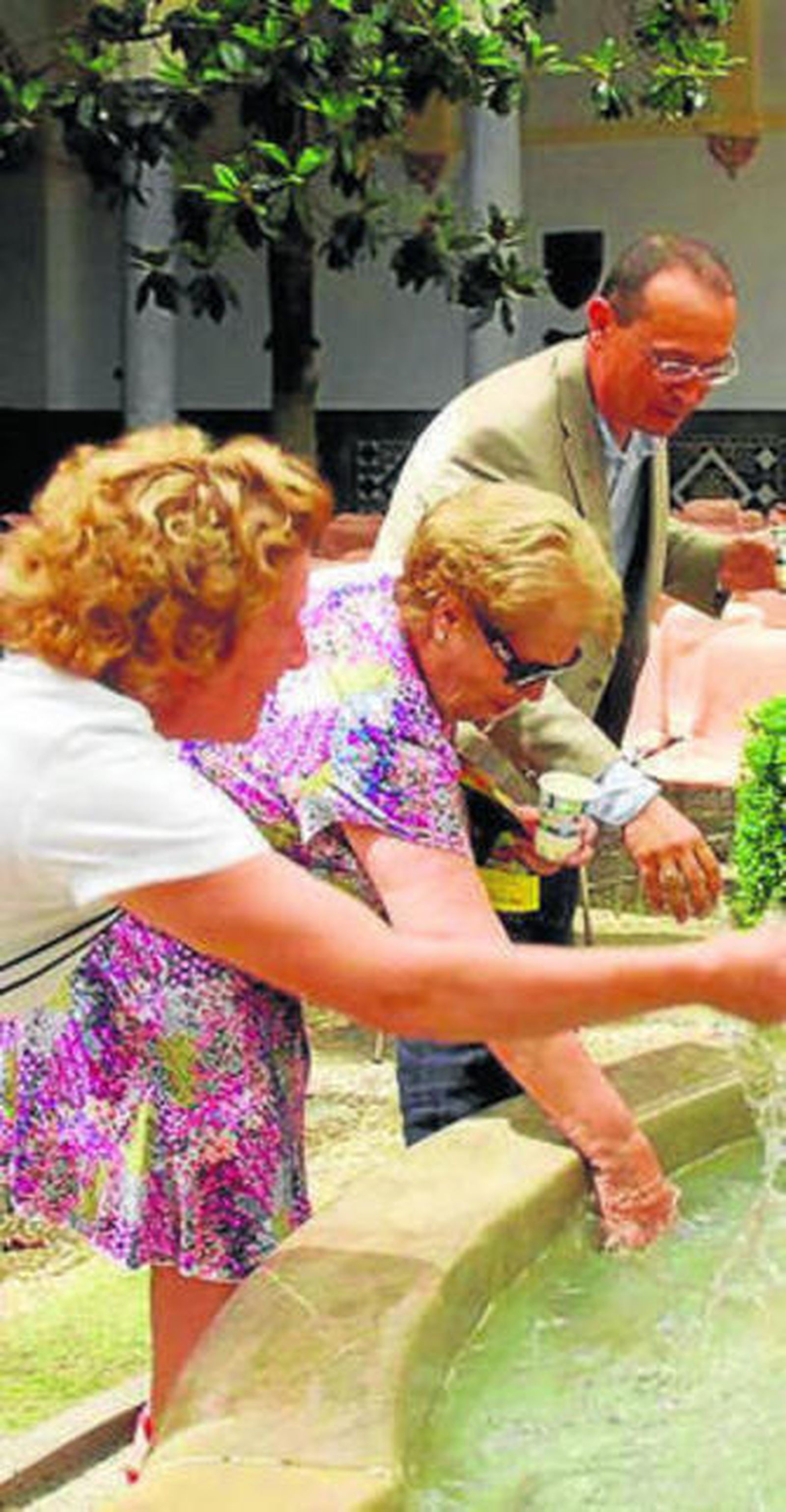 Mayores junto a una fuente.