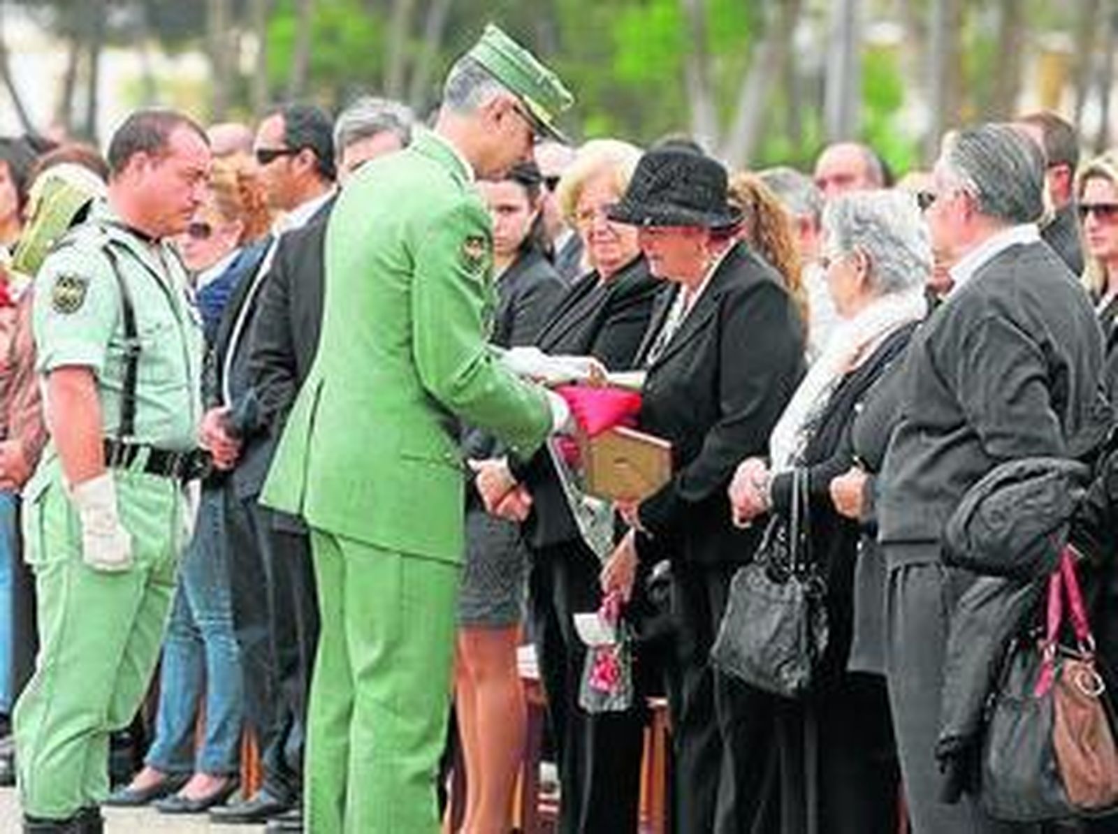 El ministro de Defensa y el general jefe de la Brileg imponen condecoraciones sobre los féretros de los fallecidos.