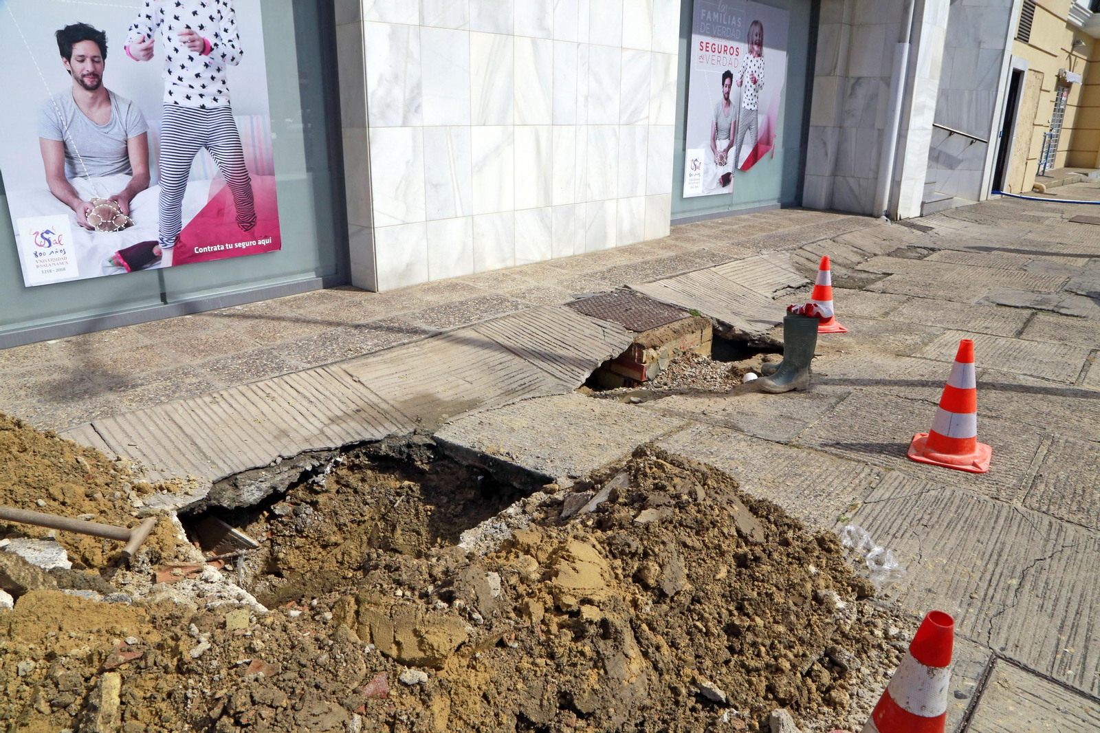 Socavón en la calle donde se encuentra la red de arquetas que provoca las filtraciones.