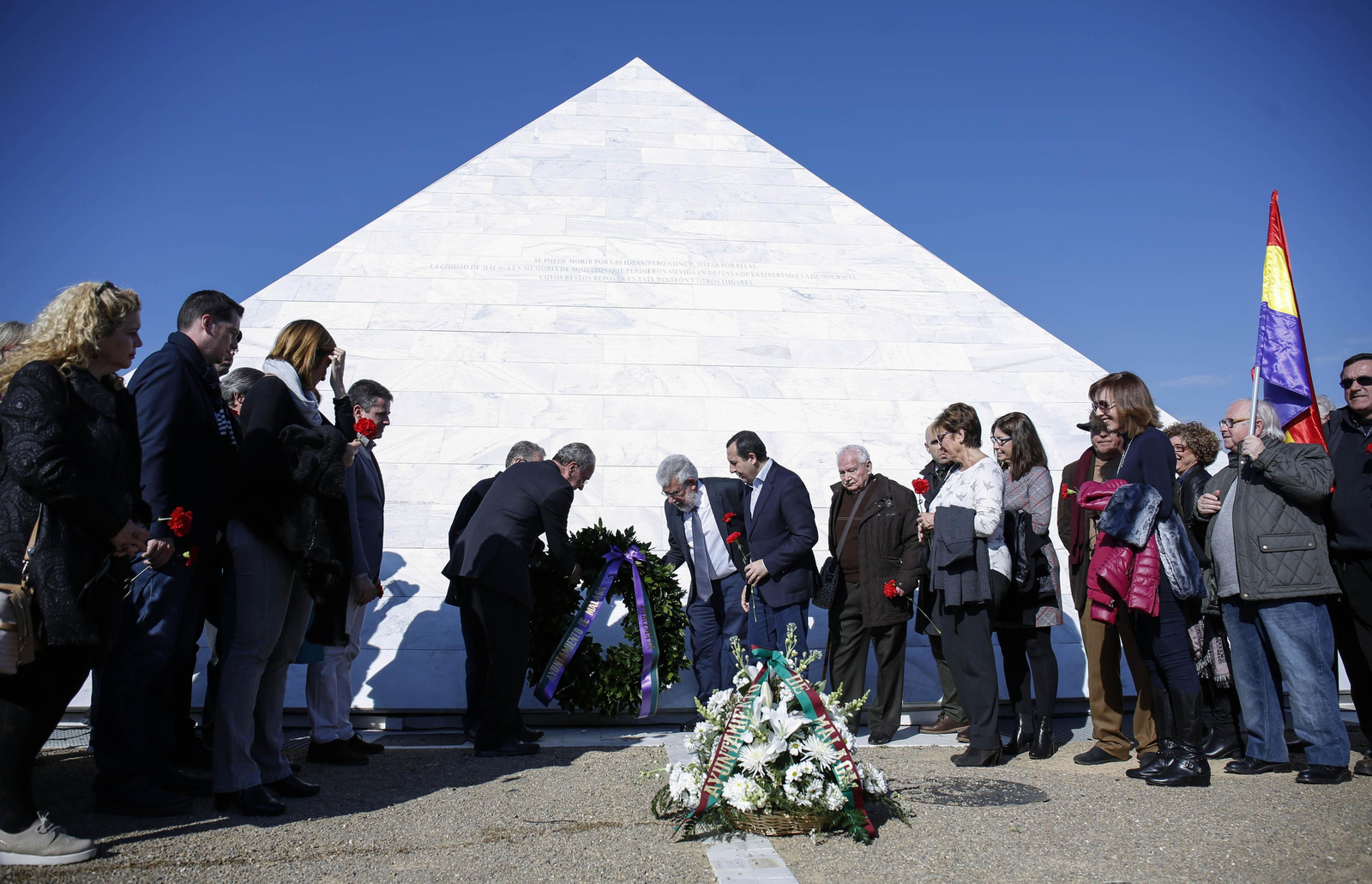 Autoridades, entidades y familiares depositan una corona en el monumento funerario.