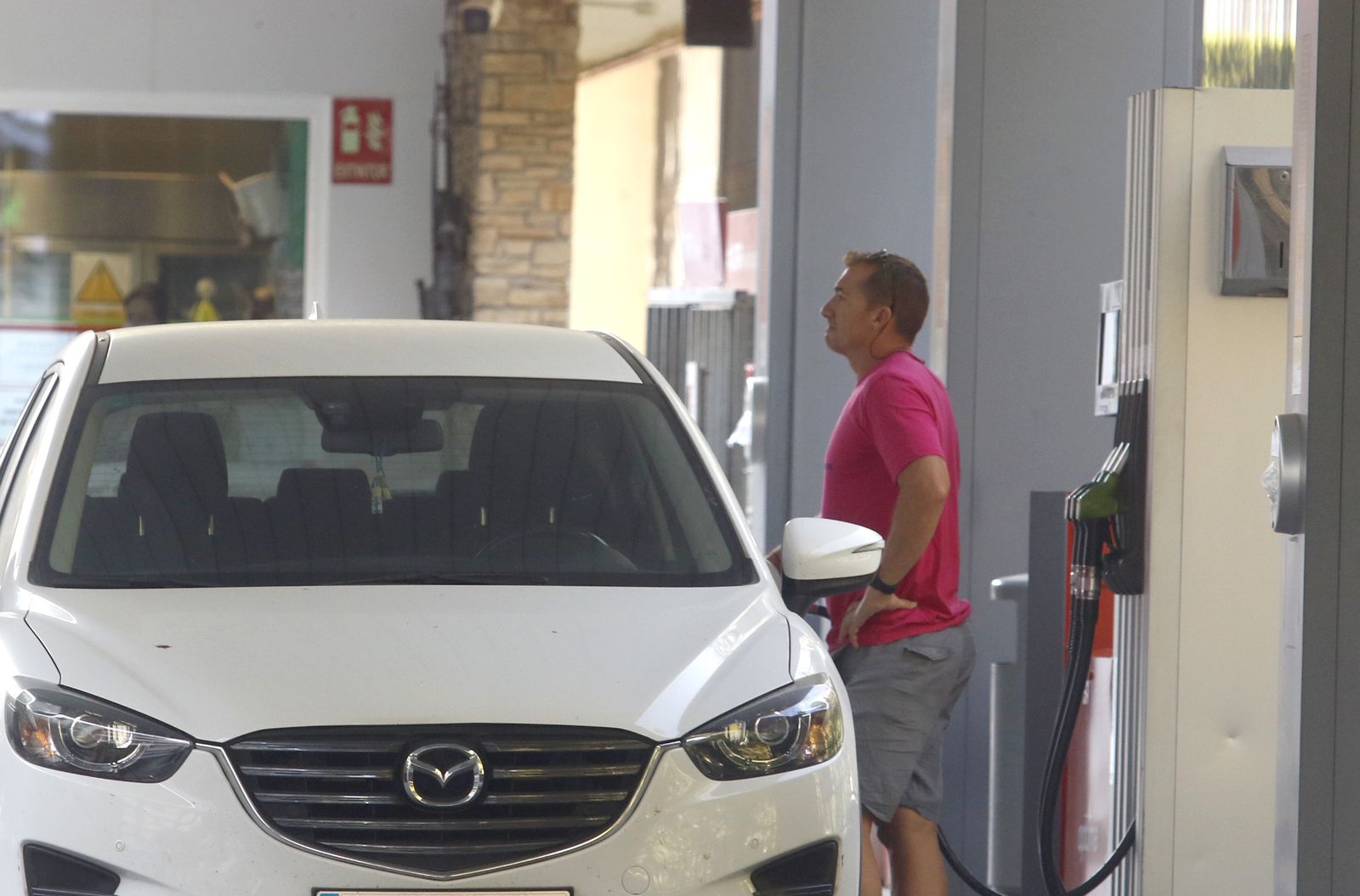 Un hombre reposta gasolina en su coche en una estación de servicio de Córdoba capital.