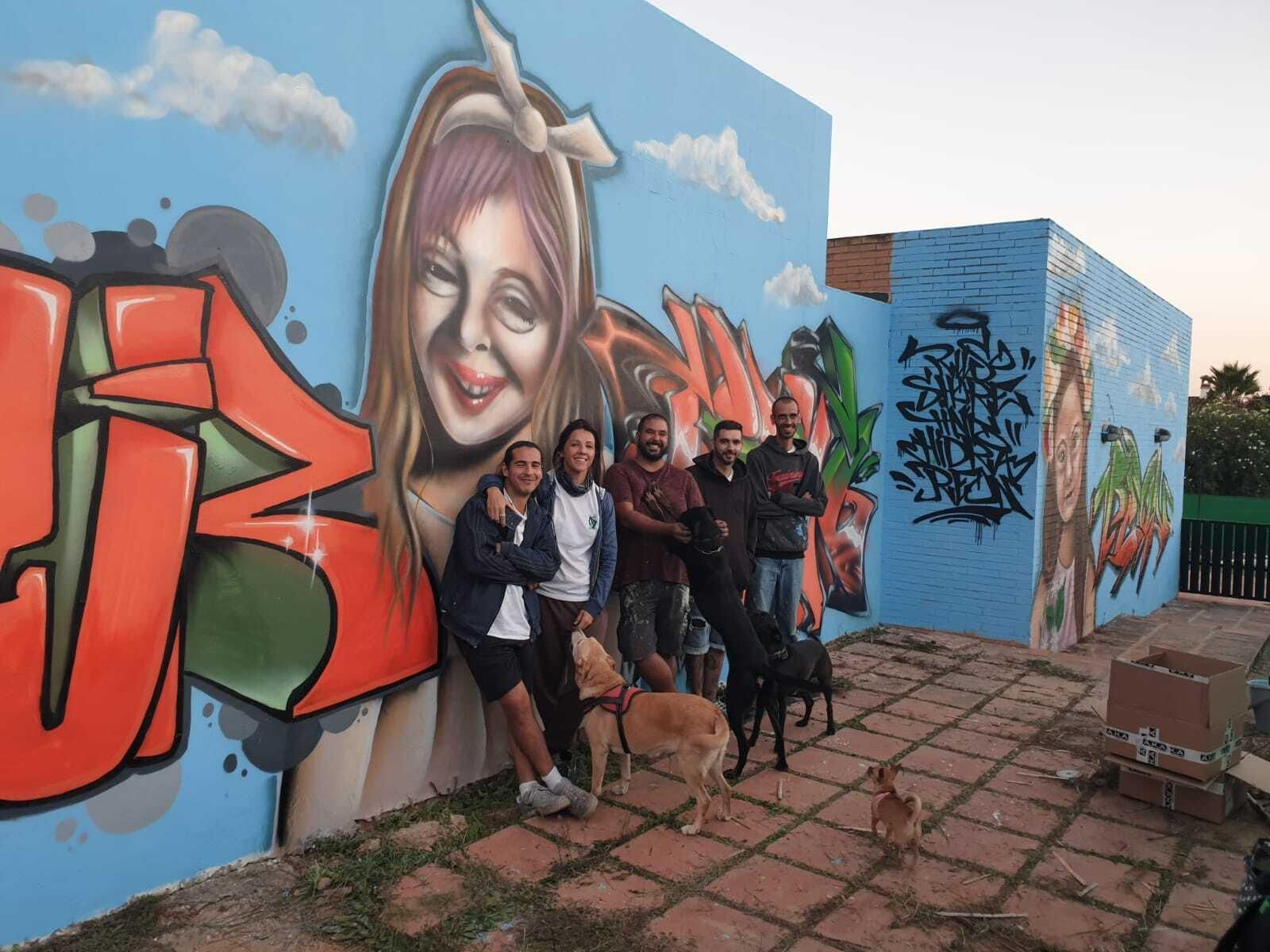 Los autores del graffiti, junto al gran mural creado en la sede de Apadeni. Los autores del graffiti, junto al gran mural creado en la sede de Apadeni.