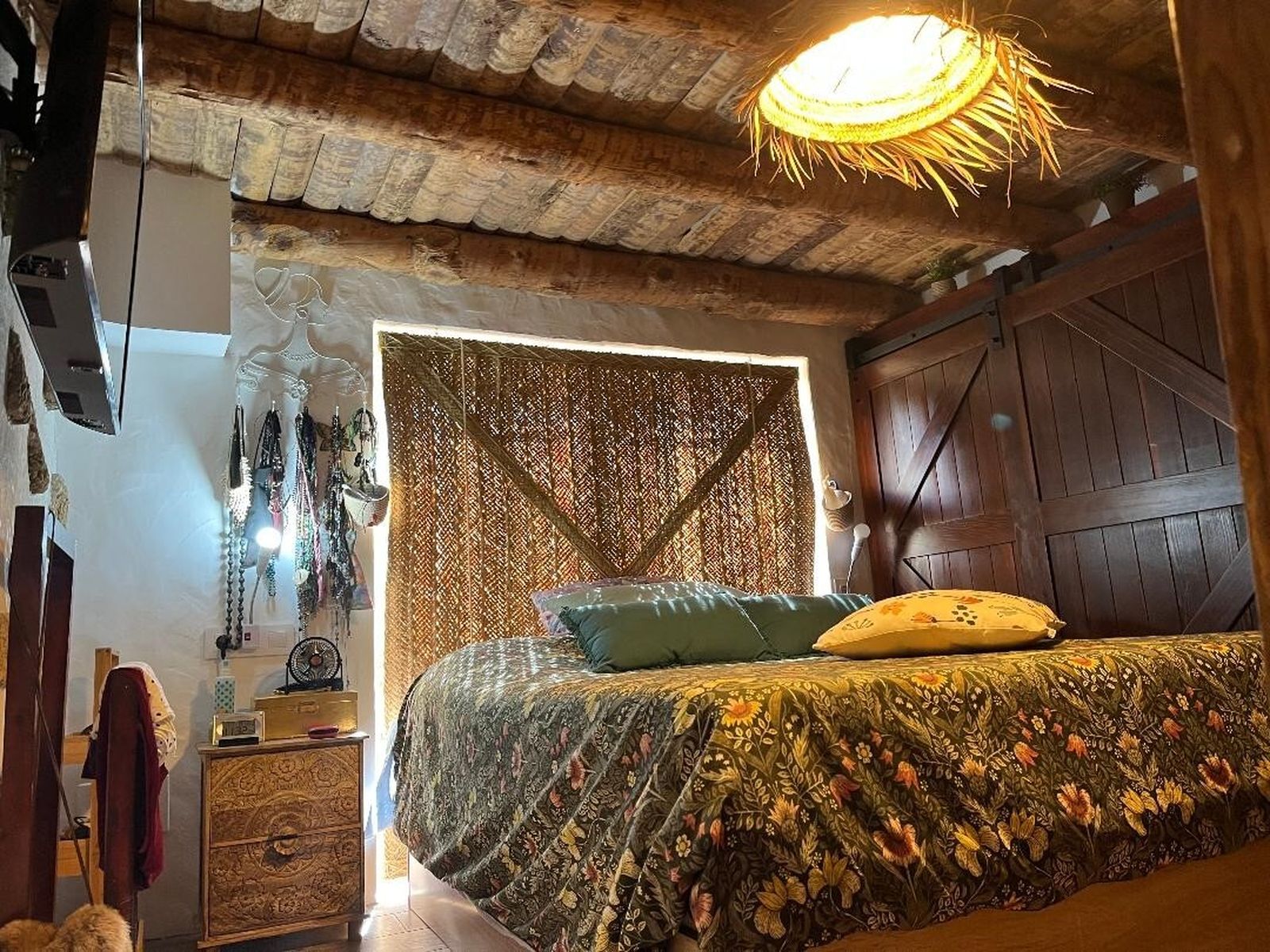 Dormitorio. Una estera que se usa de parasol se coloca como el cabecero de la cama.