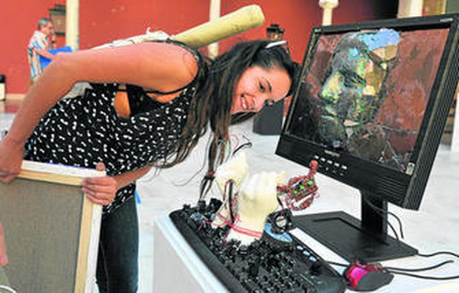 Una joven observa una de las obras expuestas en el patio de la Facultad de Bellas Artes.