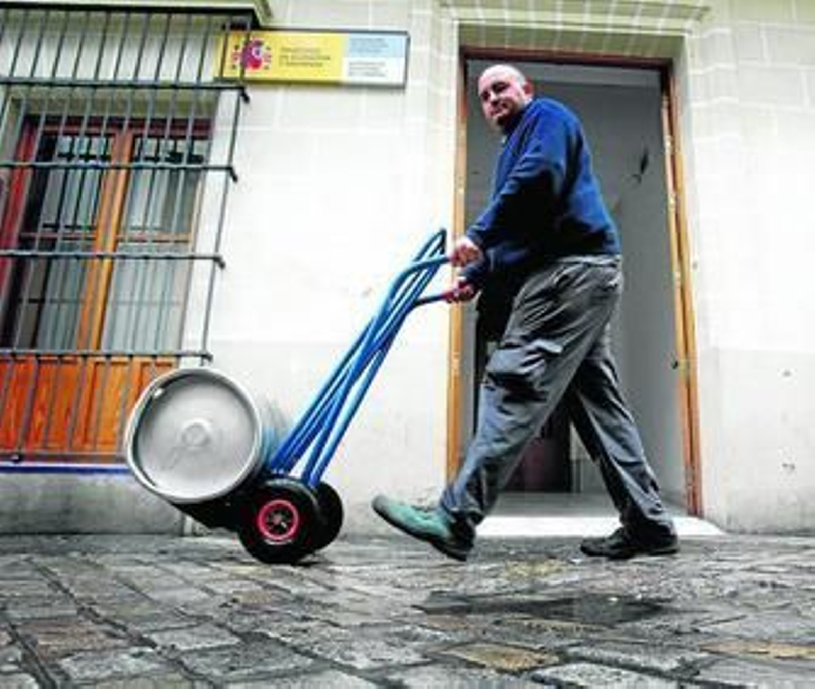 Un repartidor pasa ante la sede de la subgerencia territorial del Catastro, en la calle Tornería.