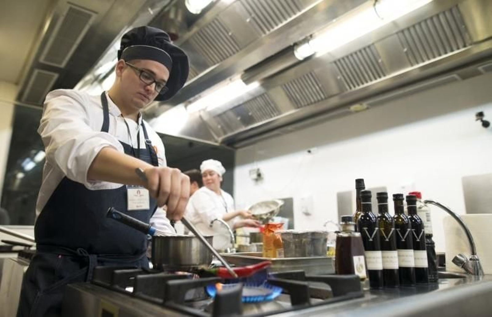 Uno de los participantes en el concurso gastronómico del Vinagre de Jerez junto a botellas del condimento jerezano.