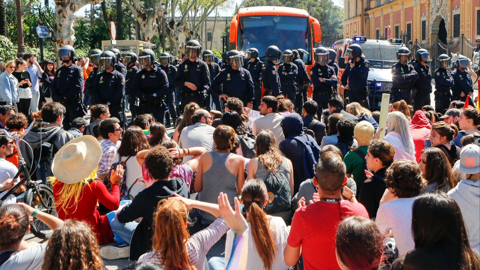 Decenas de jóvenes sentados delante del autobús y del nutrido cordón policial, el 29 de marzo de 2017.