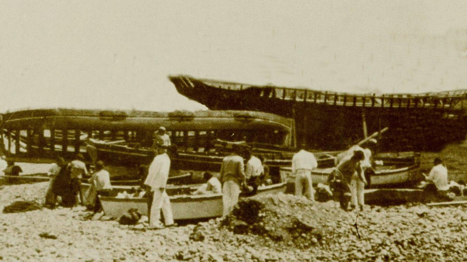 Carpinteros de ribera trabajando en la construcción de varias embarcaciones.
