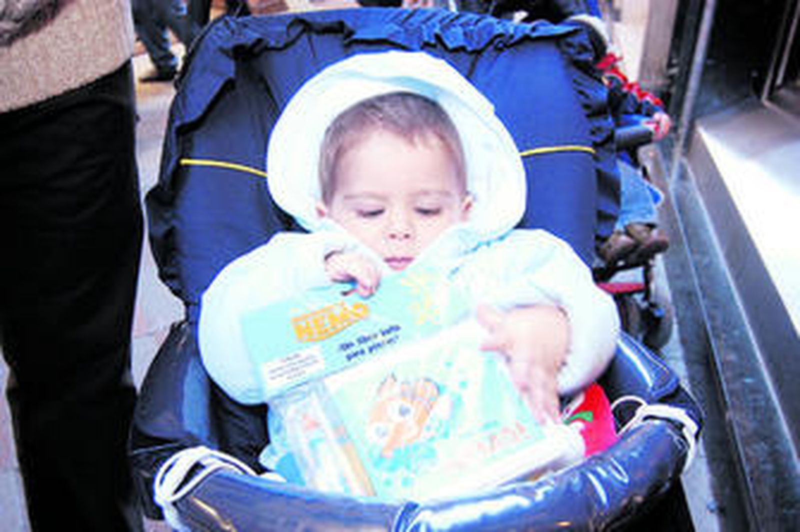 Un niño se entretiene con un libro especial para llevar a la playa ya que puede mojarse.