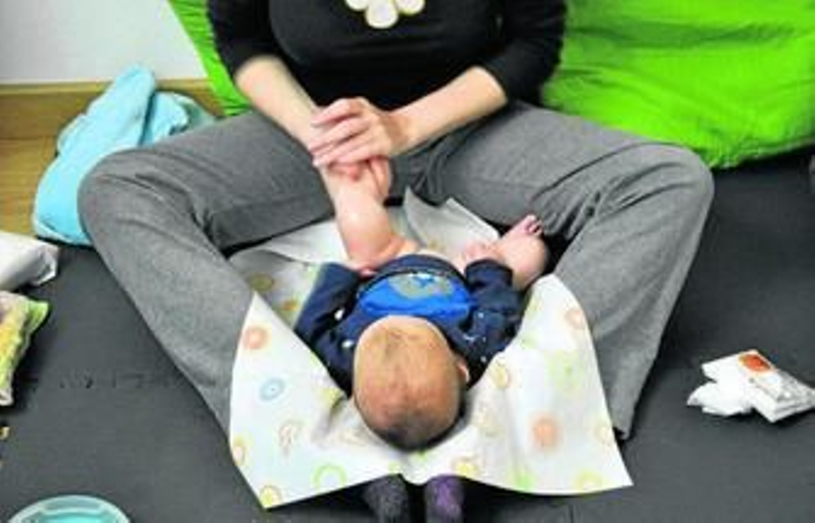 Una profesional estimula los músculos de las piernas de un bebé.