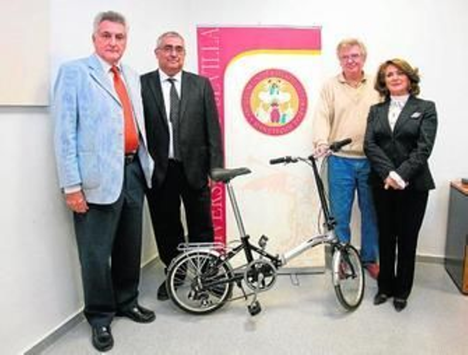Los representantes universitarios junto al modelo de bici que prestará la Hispalense.