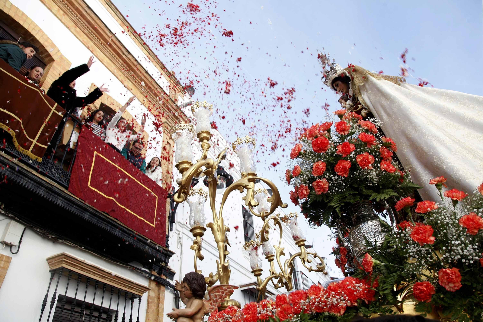 Petalada a la Virgen del Carmen durante la procesión, ayer, por las calles de Cartaya.