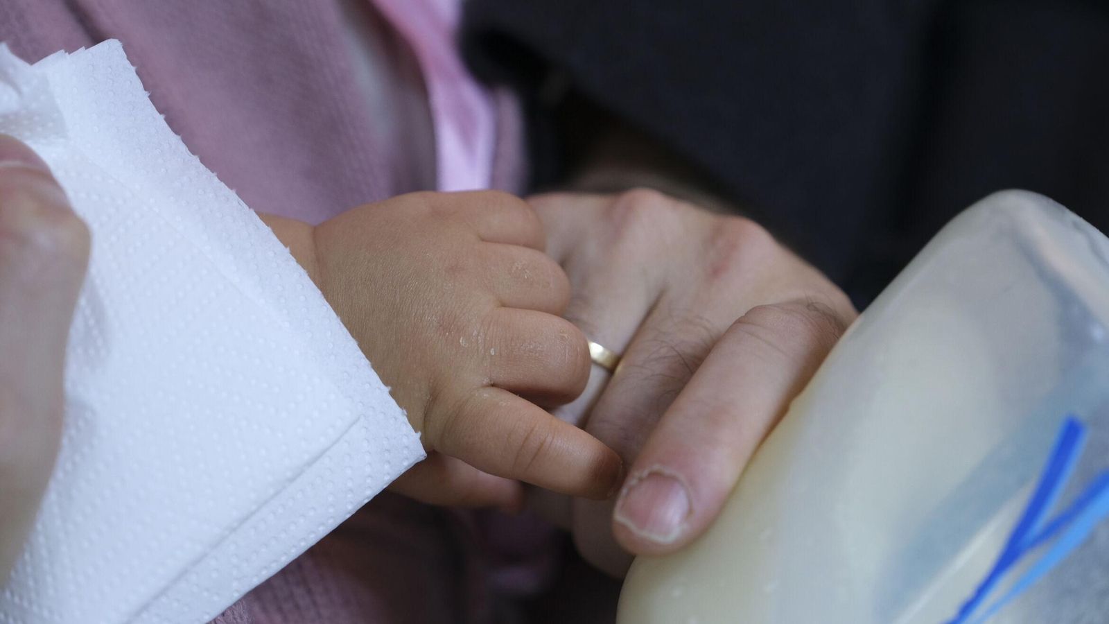 Carlos da el biberón al bebé.