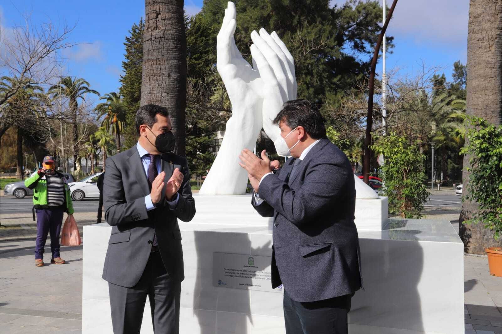 Gabriel Cruz y Juanma Moreno junto a la estatua construida en homenaje a los sanitarios.