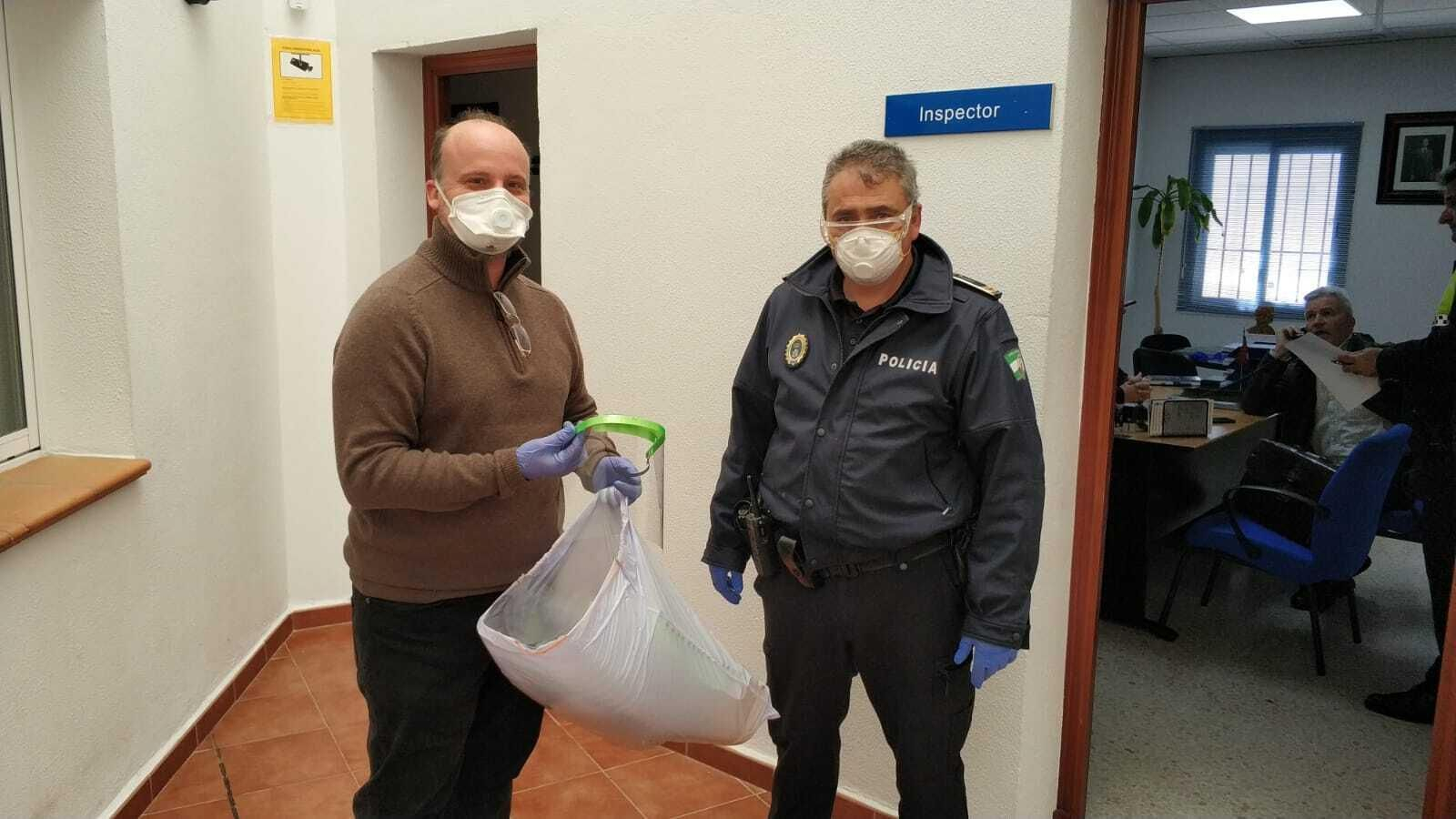 Un miembro del equipo directivo del IES Hércules hace entrega de las pantallas a la Policía.