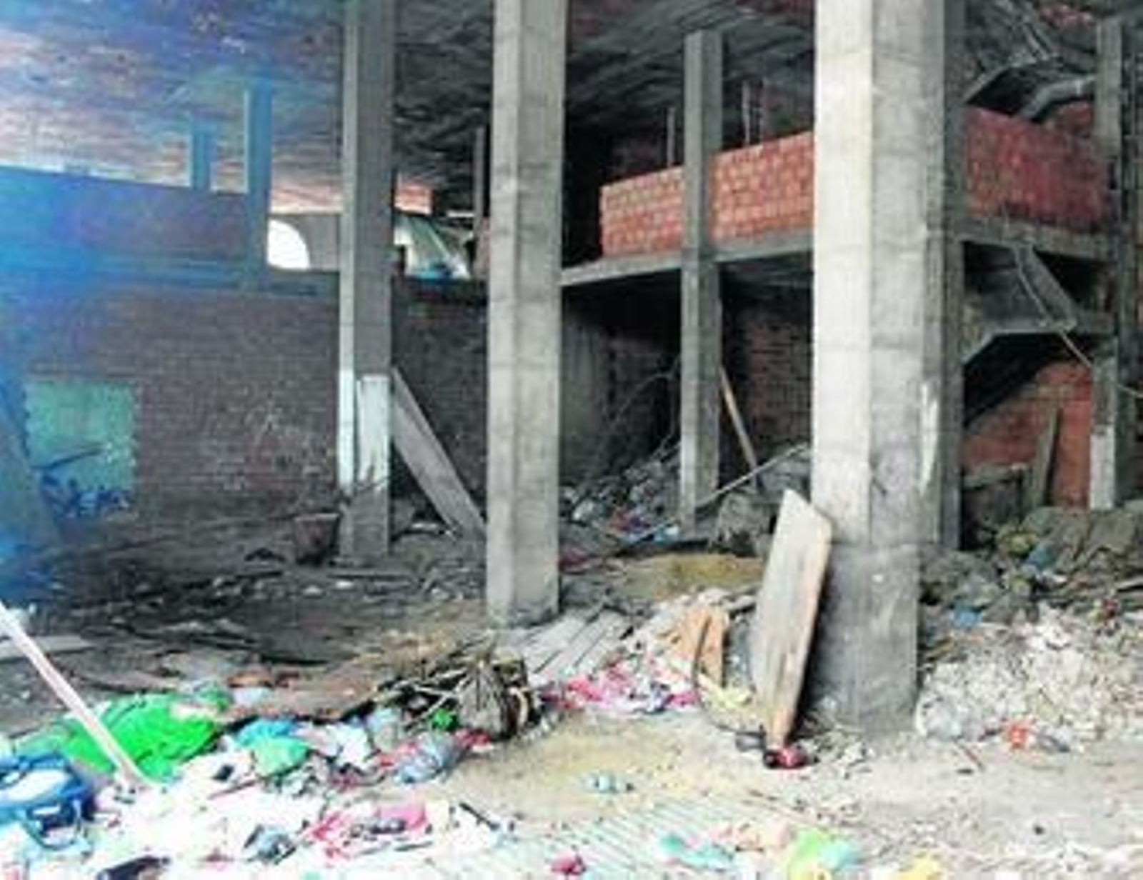 Imagen de la gran cantidad de basura que se acumula en la entrada rota del edificio, ayer.