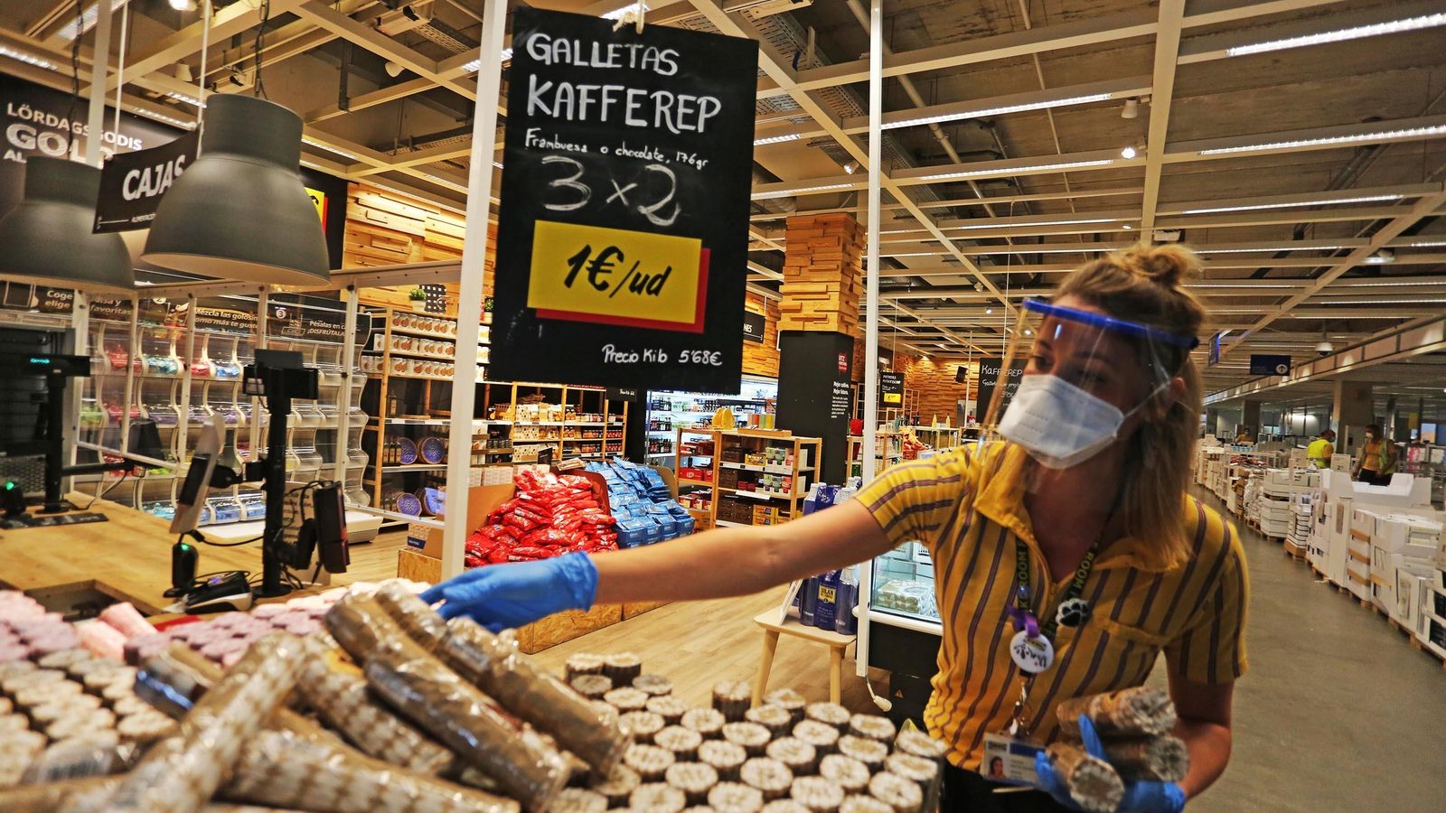 Una empleada coloca un expositor en el interior de una tienda IKEA