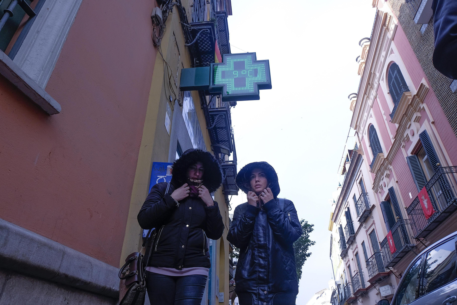 Dos jóvenes se protegen del frío.