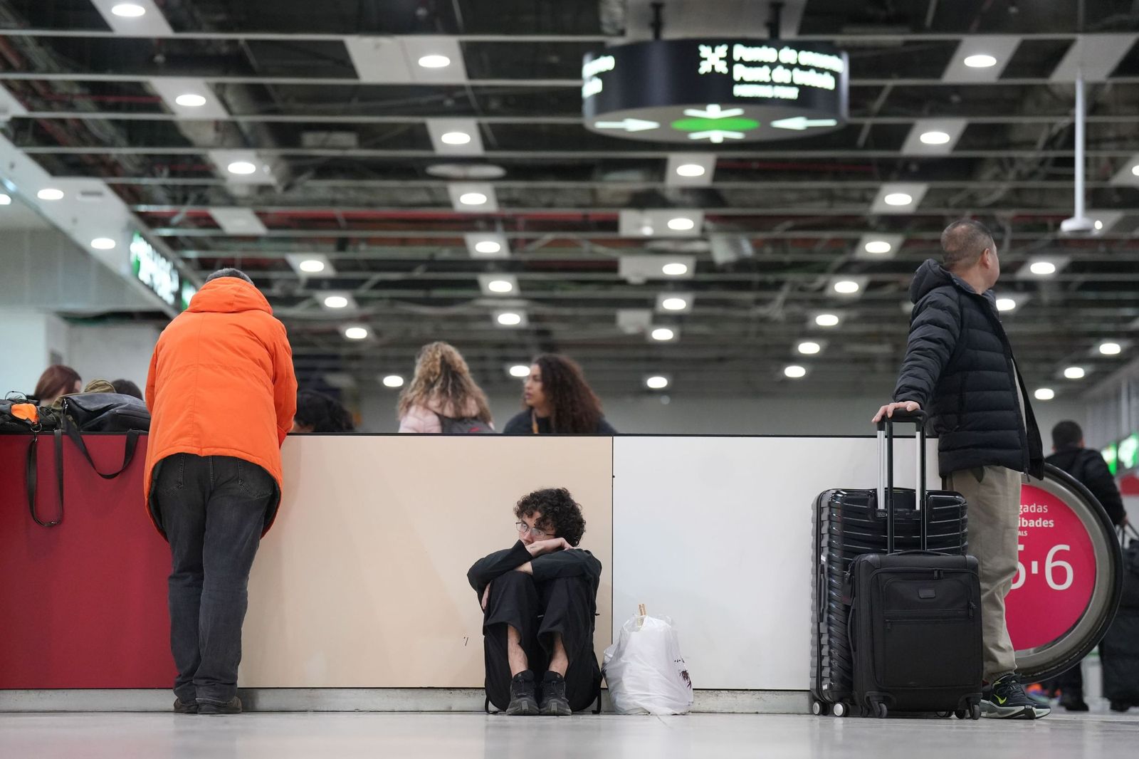 Varias personas esperan en la Estación de Sants, tras el anuncio de la suspensión del servicio de Rodalies a primera hora de este lunes.