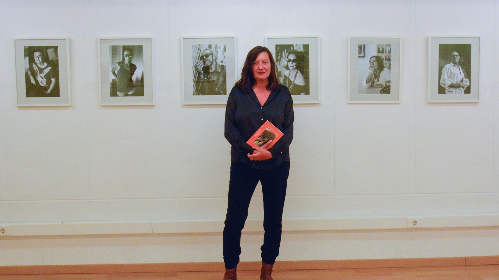 La fotógrafa Mamen Fuertes junto a algunos de los retratos de su serie Alma de Sur, en Alcultura.