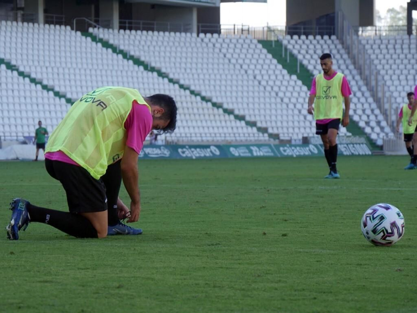 Un jugador se ata las botas durante el último partidillo del primer equipo y el filial en El Arcángel.