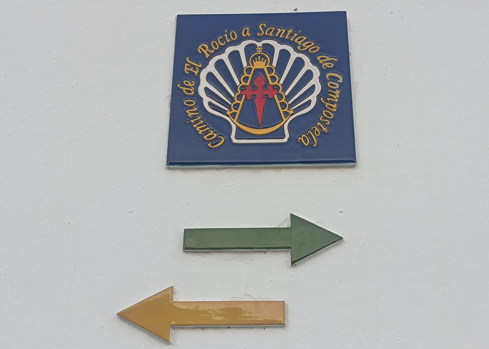 Azulejo del Camino de El Rocío a Santiago con las flechas amarilla y verde.