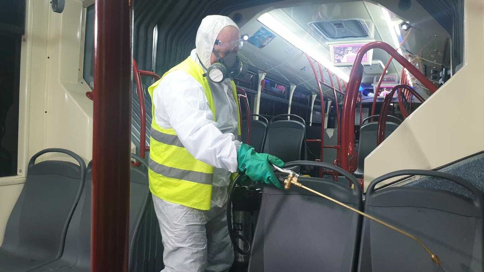 Un operario limpiando un autobús de Tussam.