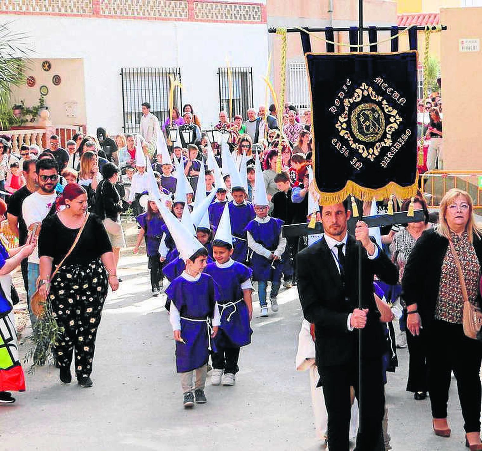 Inicio de la procesión, con el estandarte y los pequeños penitentes.