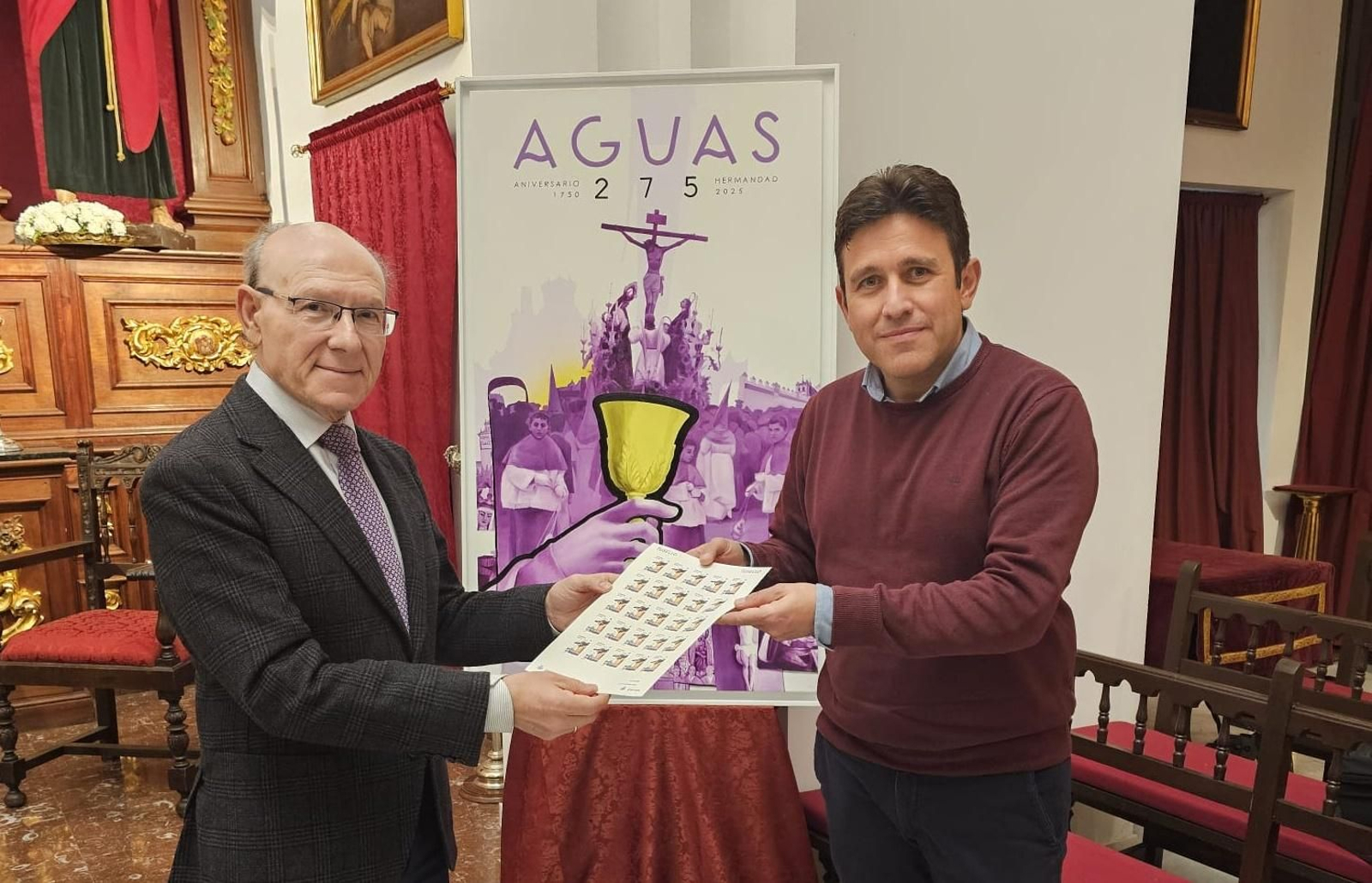 El hermano mayor, a la izquierda, recibe el pliego de los sellos de Correos