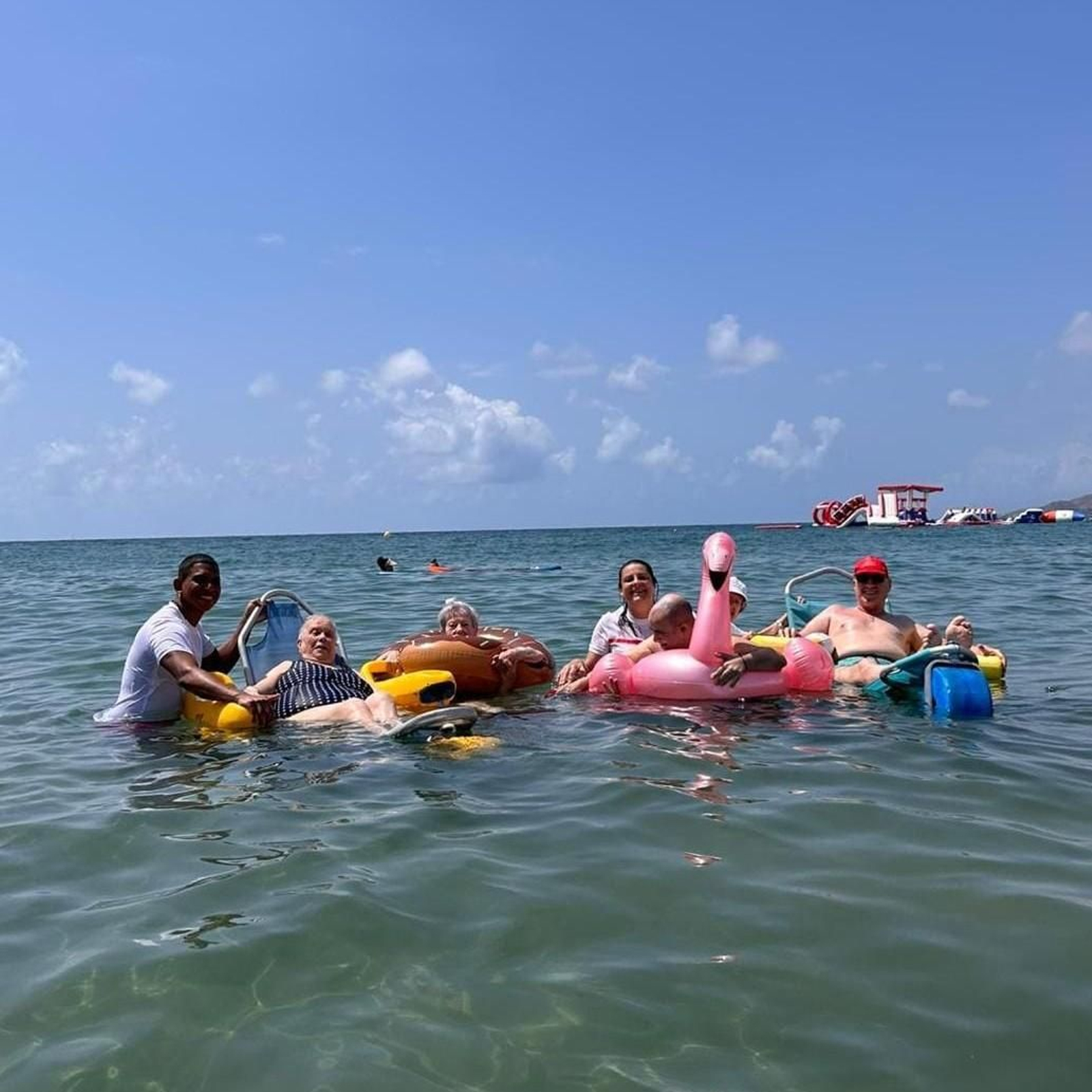Personal de Cruz Roja asiste a los mayores durante el baño en Playa Serena.