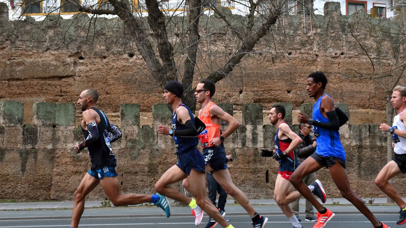 Participantes en el Maratón de Sevilla a su paso por la Muralla de la Macarena.