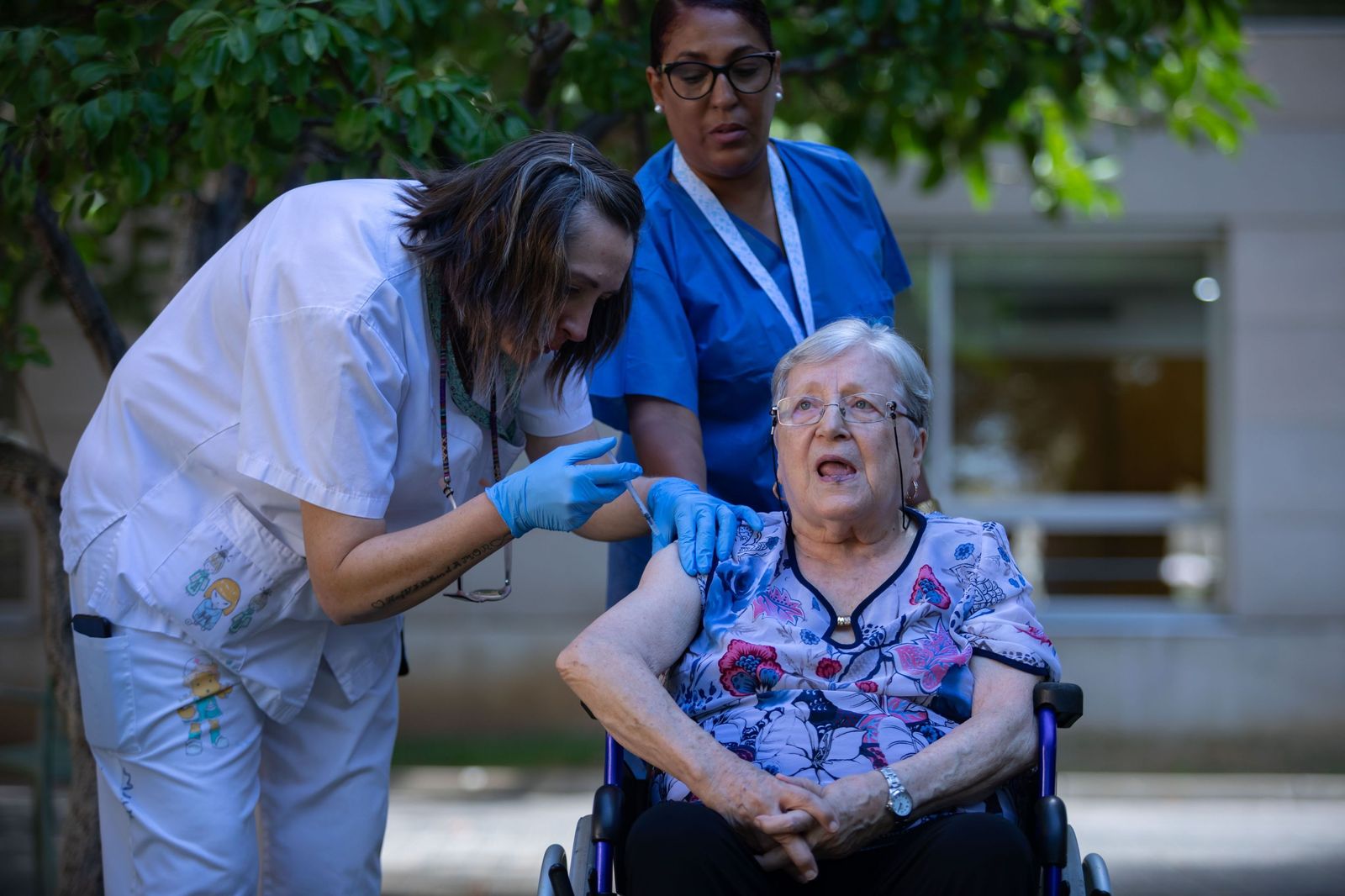 Una enfermera inyecta una vacuna a una paciente