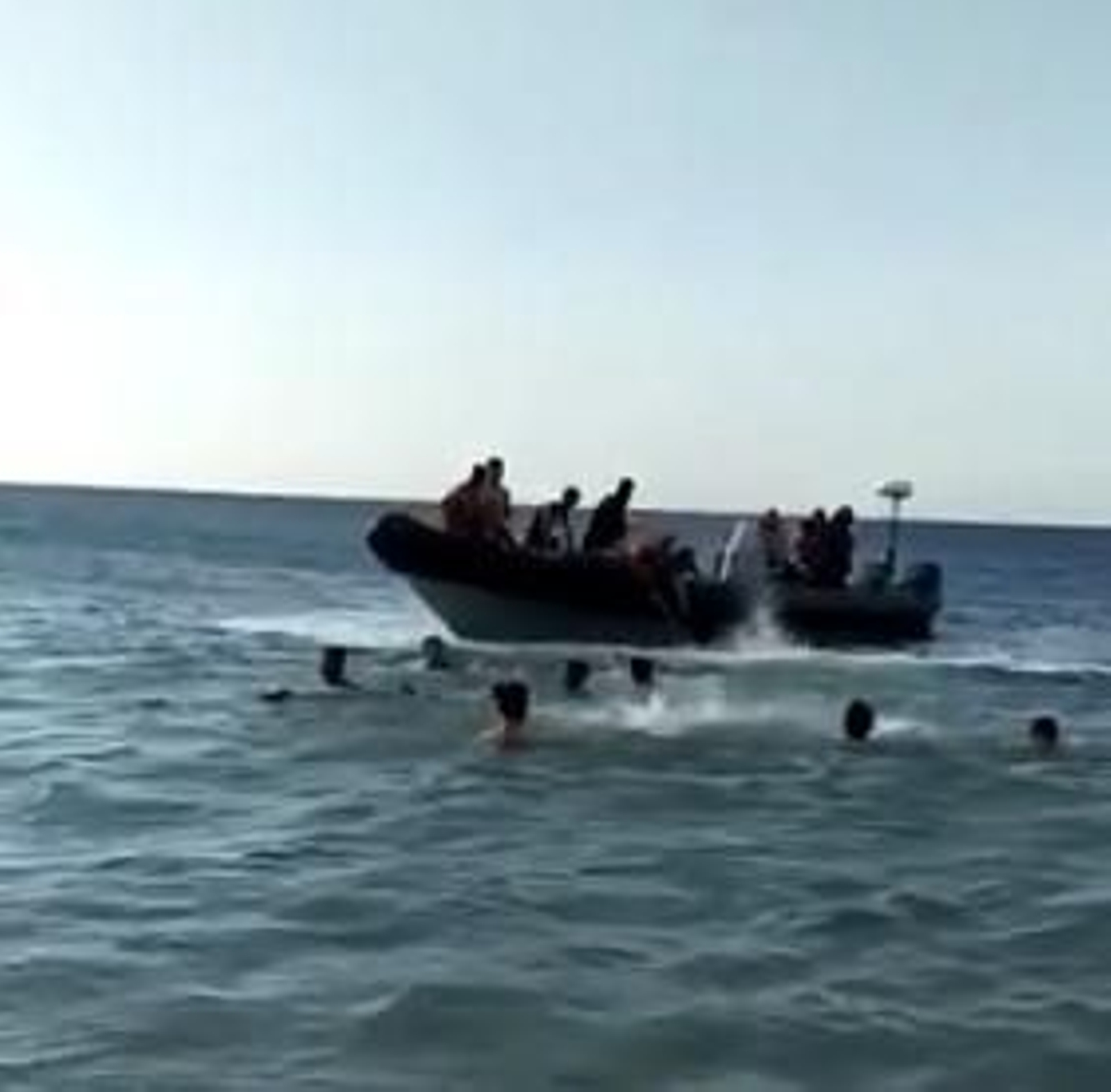 Varios migrantes en torno a una semirrígida junto a las costas de Tarifa.