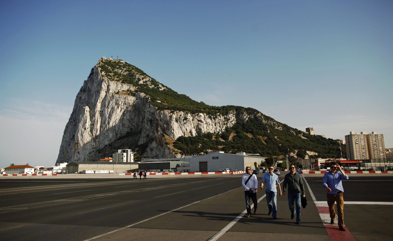 Un grupo de personas atraviesa la pista del aeropuerto de Gibraltar.