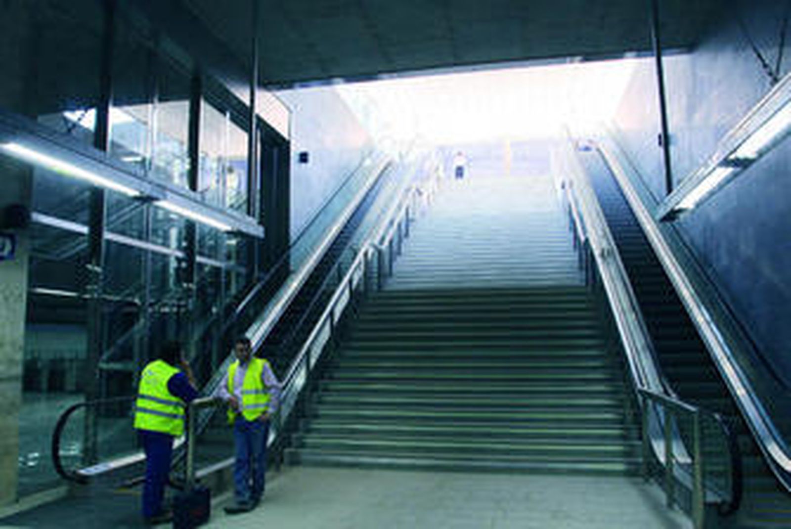 Dos operarios charlan en la escalera de entrada a la estación del Metro de San Bernardo.