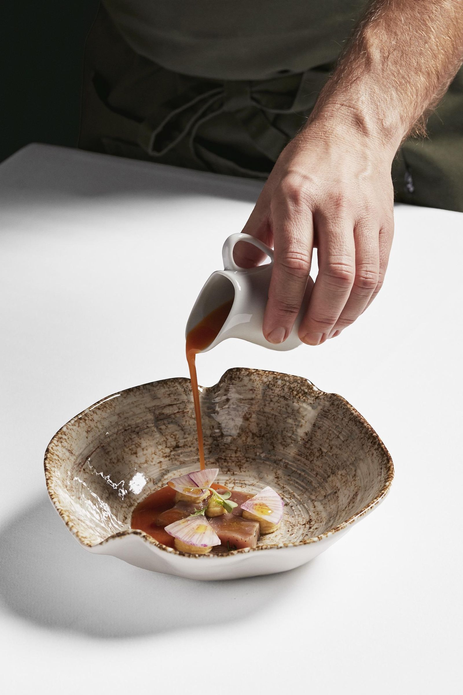 Detalle plato de corvina en salazón, salsa de adobo y verduras del Navazo