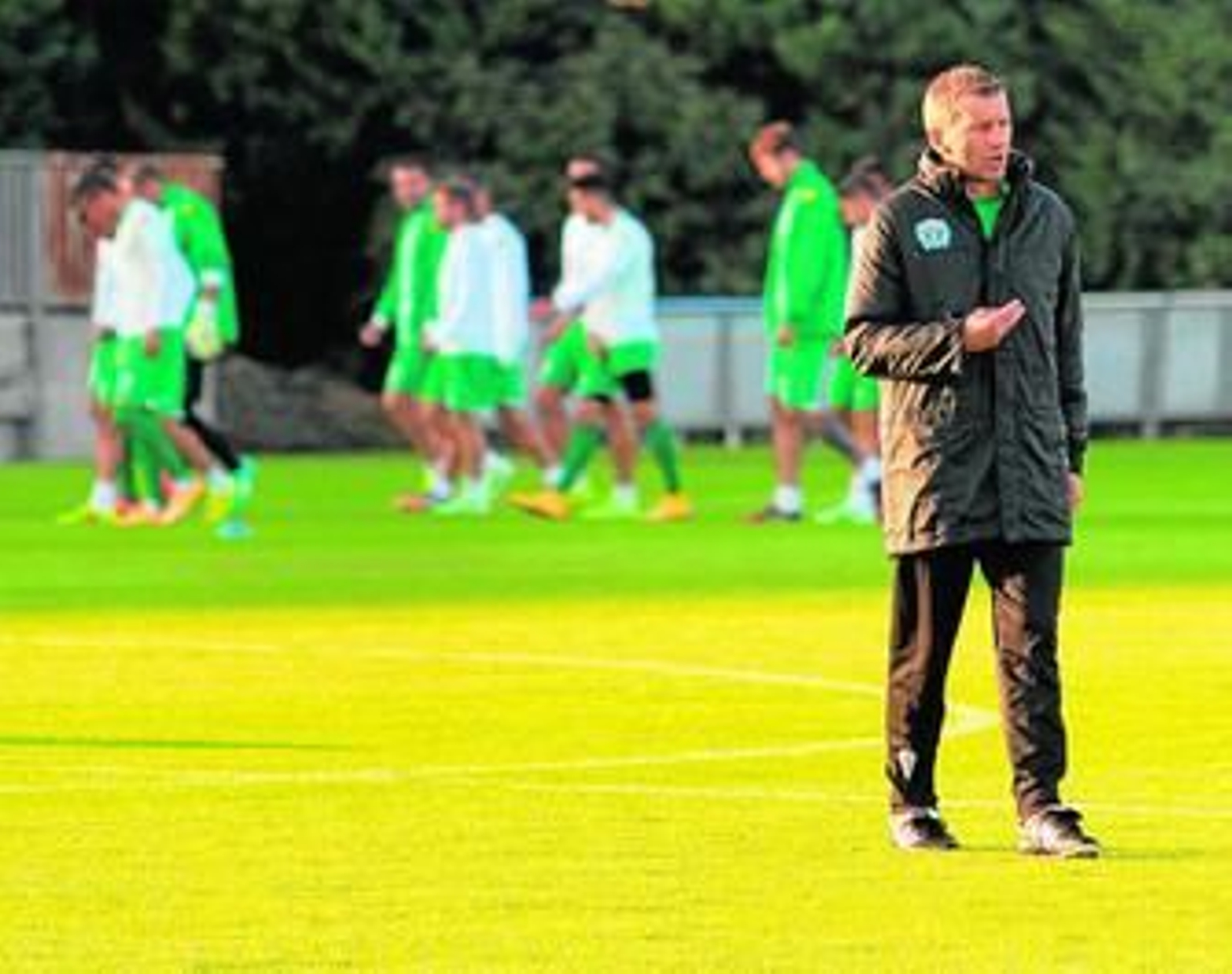Miroslad Djukic gesticula durante una sesión de trabajo con los jugadores al fondo.