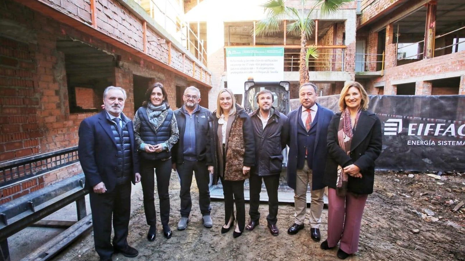 Responsables de la consejería de Fomento y de la constructora en el patio de la promoción.