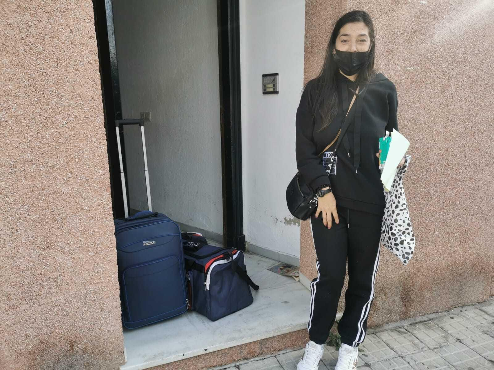 Carmen, a las puertas de la vivienda con la maleta que ha  podido sacar antes del desalojo.