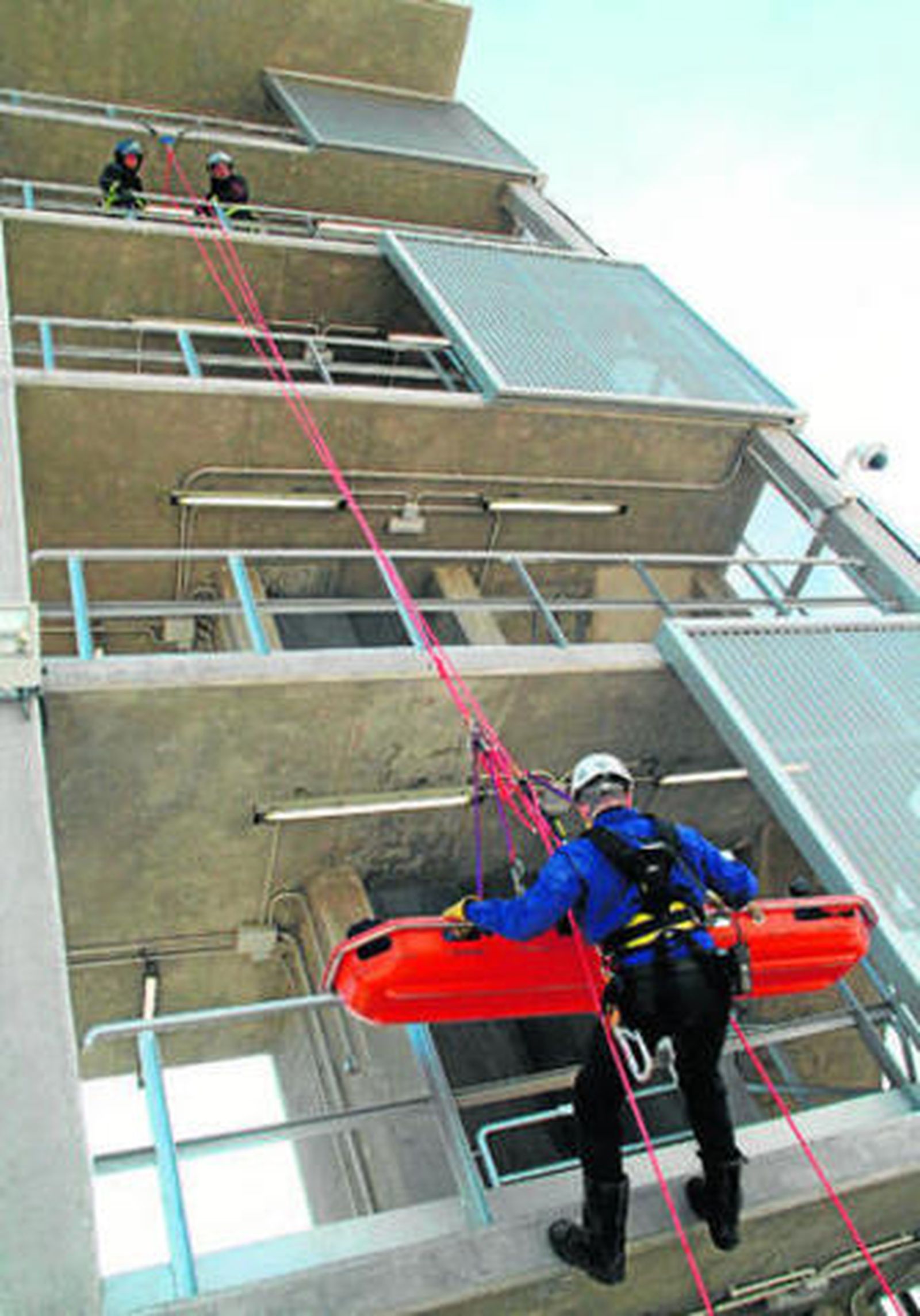 La unidad de bomberos de Cepsa realiza un simulacro de bajada vertical de una camilla con herido, ayer.