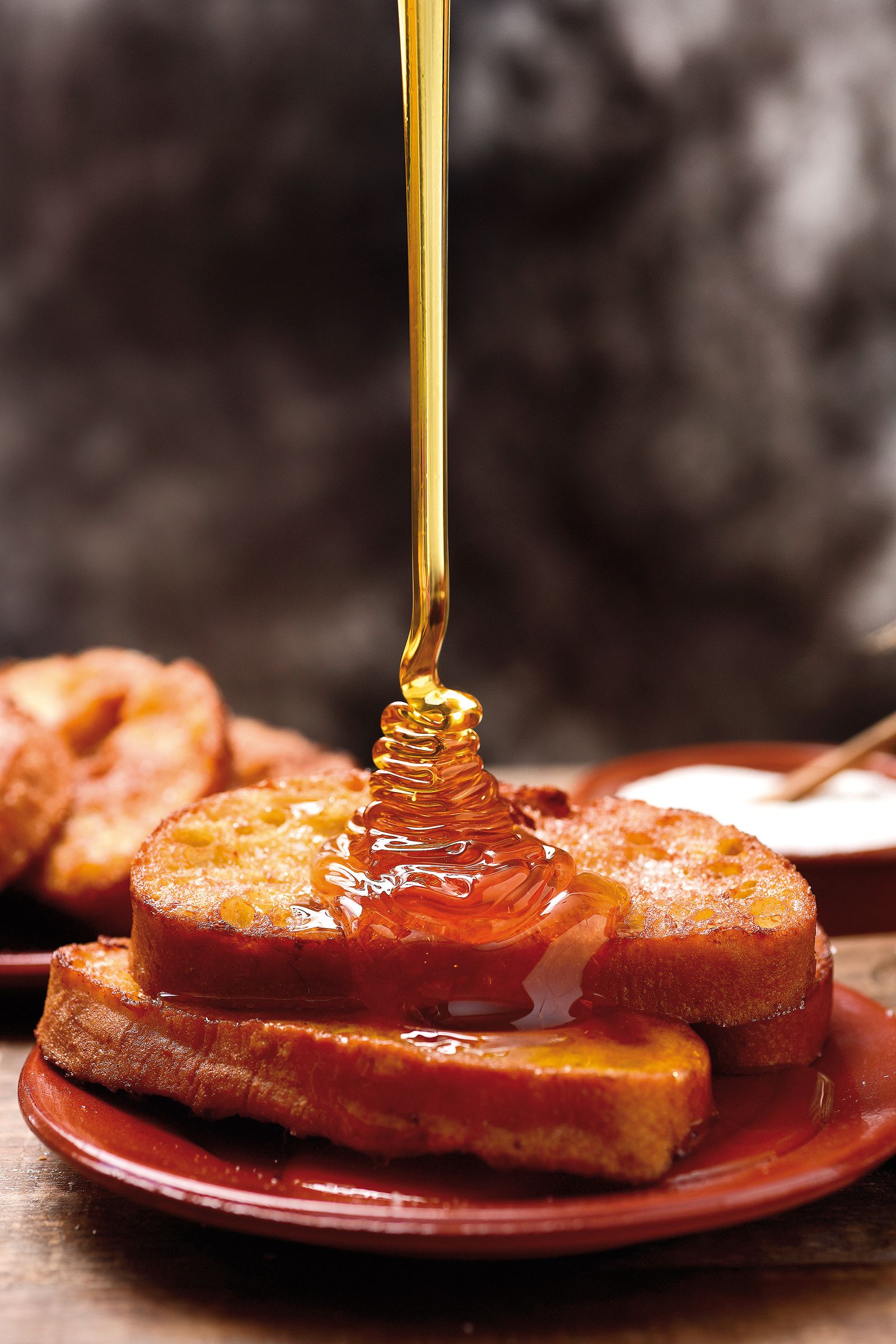 La miel cae sobre esta torrija, otro de los dulces típicos de la Semana Santa sevillana.