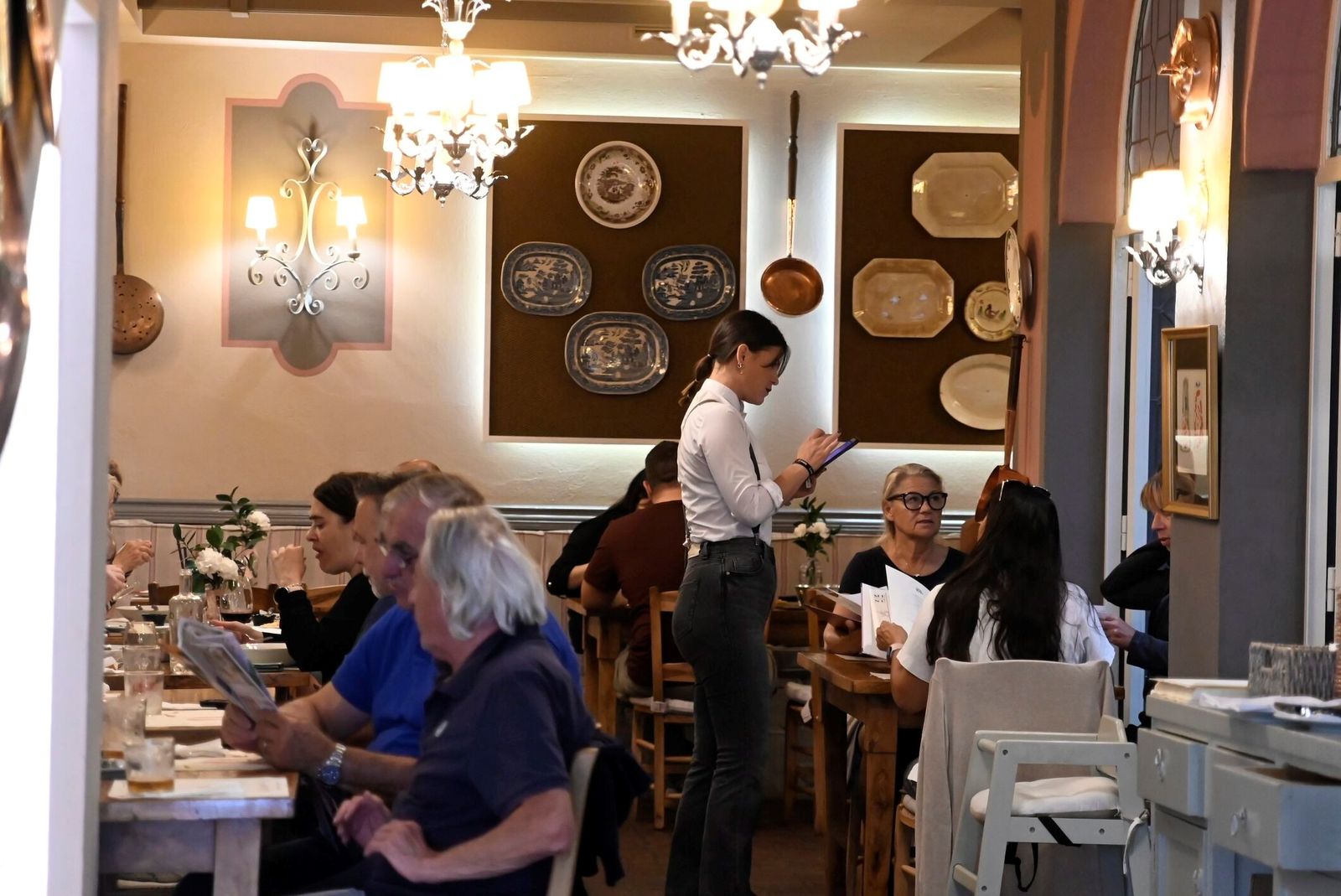 Una camarera atiende a unos clientes en un restaurante de Córdoba.